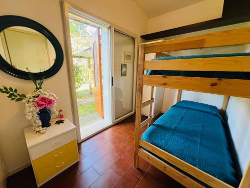 Un dormitorio con una litera y un espejo. en Villa Pinocchia, en Bibione