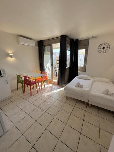 une chambre avec un lit, une table et des chaises dans l'établissement Résidence Graziella Studio 507, à Juan-les-Pins