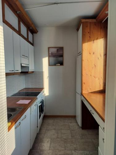 a kitchen with white cabinets and a stove top oven at LibO-apartment, Inkilä 23 X in Kuopio