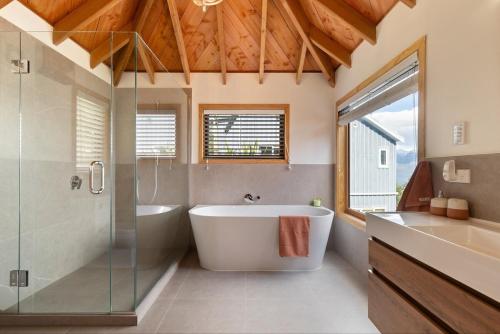 a bathroom with a tub and a glass shower at Majestic Waters in Queenstown