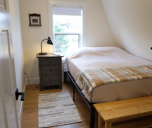 a bedroom with a bed and a dresser and a window at The Harbour House Montague in Montague