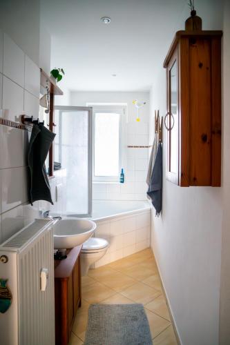 a bathroom with a sink and a toilet and a tub at Zentral Bahnhof Salz&Sand 75m2 Apartment in Halle an der Saale