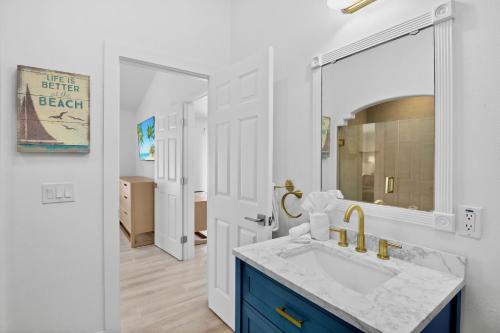 a bathroom with a sink and a mirror at Little Pink Houses in Anna Maria