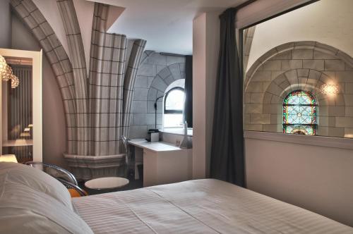 a bedroom with a bed and a sink and a window at SOZO Hotel in Nantes
