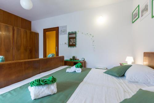 a large bedroom with a large bed with green sheets at Home Away From Home with a heated pool in Punat
