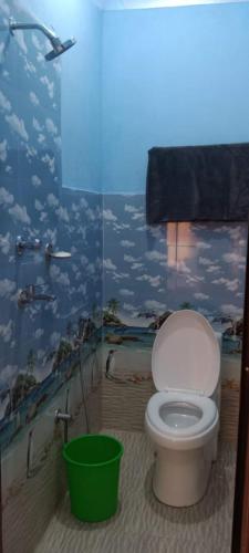 a bathroom with a toilet with a mural of clouds at KharidhugaHotel and lodge in Rāmechhāp