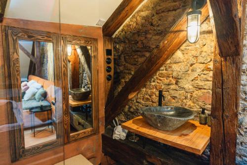 a bathroom with a sink and a stone wall at King's Royal Apartments in City Centre in Prague