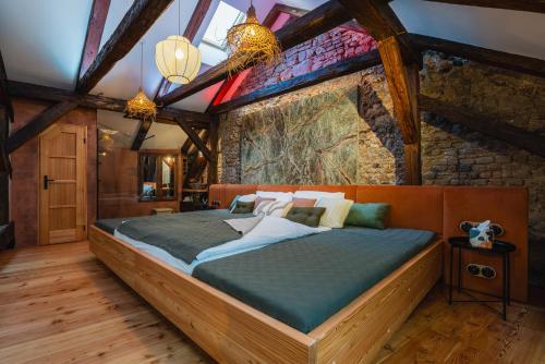 a bedroom with a bed in a room with a stone wall at King's Royal Apartments in City Centre in Prague