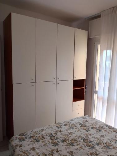 a bedroom with a bed and a large white cabinet at Dolce Relax - Sottomarina in Sottomarina