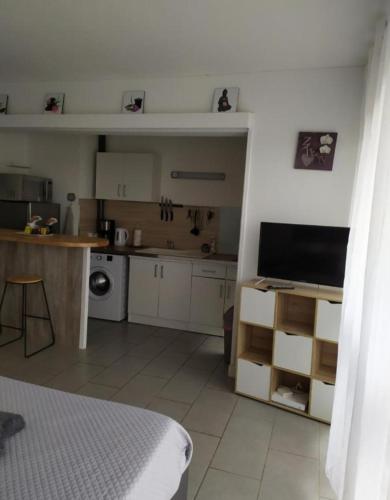 - une cuisine avec des placards blancs et une télévision dans la chambre dans l'établissement studio 127, à Sens