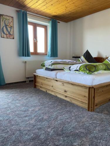 a bedroom with a large bed with blue curtains at Ferienwohnungen Paukner in Sankt Englmar