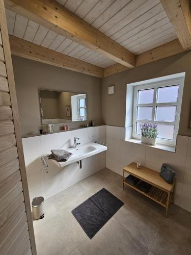 a bathroom with a sink and a window at Ferienhaus Mühle 7 in Krummhörn