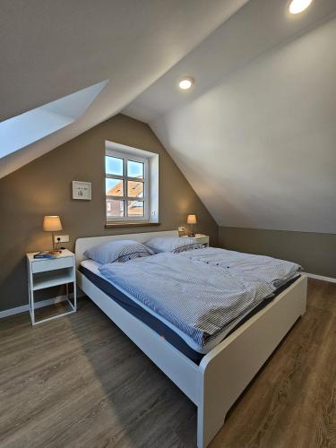 a bedroom with a large bed and a window at Ferienhaus Mühle 7 in Krummhörn