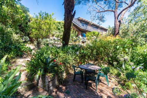 a patio with a table and chairs in a garden at Dromana Tree House Private Gardens & Ocean Views in Dromana