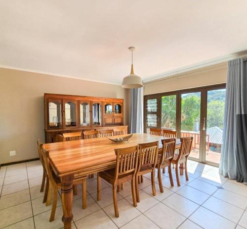 a dining room with a wooden table and chairs at Randall House in Gonubie