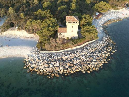 an island with a building in the water at VVR6 Apartment by Homes in Ancona in Ancona