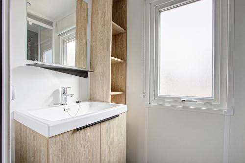 un bagno con un lavandino bianco e una finestra di Camping Barberousse a Gruissan