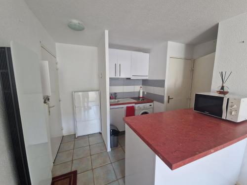 - une cuisine avec un comptoir et un four micro-ondes dans l'établissement Petite Venise, à Sète