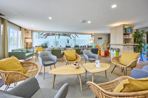 a waiting room with chairs and tables at Résidence Pierre & Vacances le Green Beach in Port-en-Bessin-Huppain