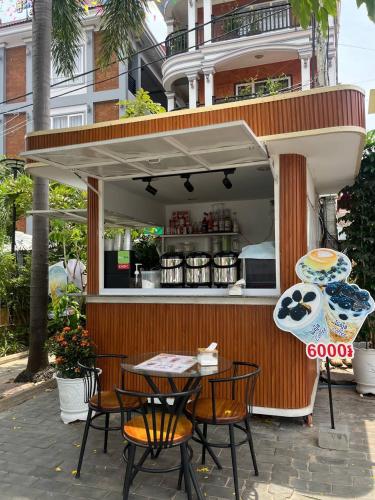 a table and chairs in front of a food stand at Jasmine Lodge Siem Reap in Siem Reap