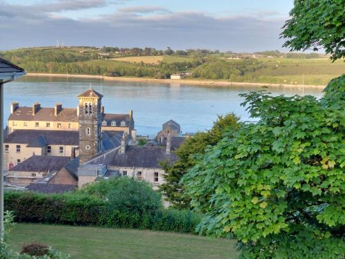 a building with a clock tower next to a body of water at Happy Sandy Feet in Youghal