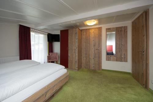 a bedroom with a large bed and wooden cabinets at Pension Appartments Christoph in Westendorf