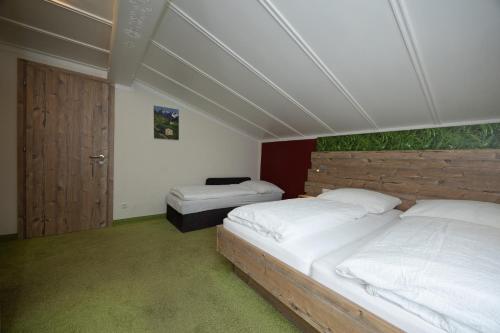 a bedroom with two beds and a wooden headboard at Pension Appartments Christoph in Westendorf