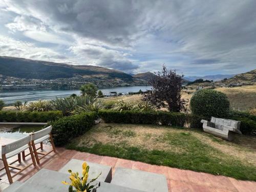 two benches on a patio with a view of a river at Sunbeam Hideaway Kelvin Heights in Queenstown