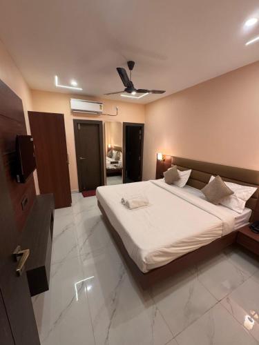 a bedroom with a large white bed with a ceiling at Skyfarm Resort in Barāgaon