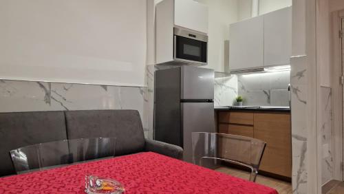 a kitchen with a table with a red table cloth at Giudei House Torri in Bologna