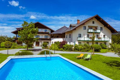 an estate with a swimming pool in front of a house at Pension Anna in Mondsee