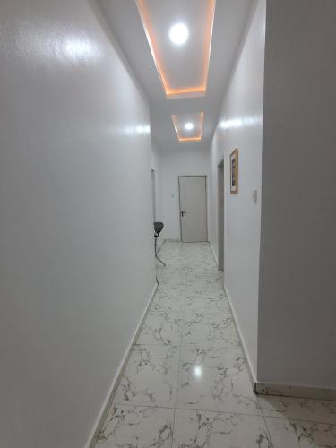 a hallway with a white wall and a ceiling at Comfort Homes - Cozy Apartment in Egbeda in Okunola