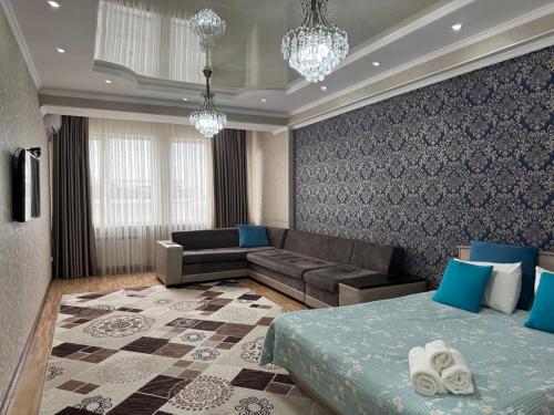 a living room with a bed and a couch at AlaNest Apartment in Bishkek