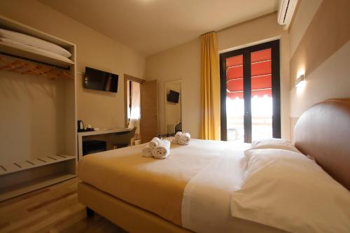 a hotel room with a bed with towels on it at Hotel Primavera in Peschiera del Garda