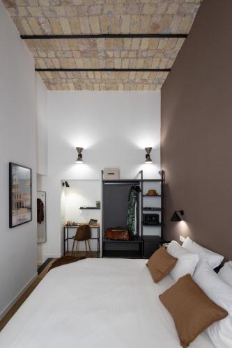 a bedroom with a large white bed with a wooden ceiling at Style & Stone Guest House in Rome