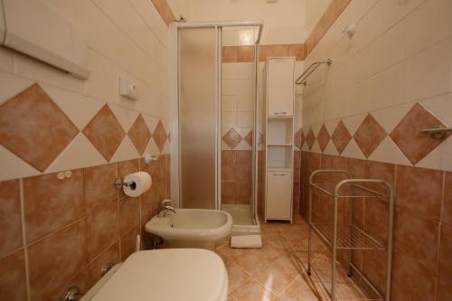 a bathroom with a toilet and a shower and a sink at Hotel Primavera in Peschiera del Garda