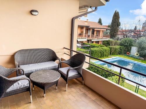 a balcony with chairs and a table and a swimming pool at Casa Boschette in San Felice del Benaco
