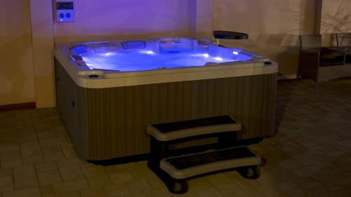 a jacuzzi tub with a stool in a room at Csillag Panzió in Vác