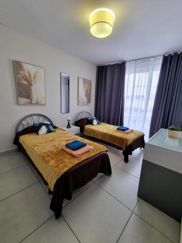 a room with two beds and a window at Bay Water 21 in St. Julianʼs