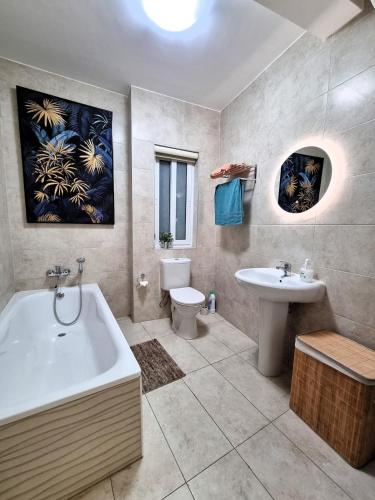a bathroom with a tub and a toilet and a sink at Bay Water 21 in St. Julianʼs