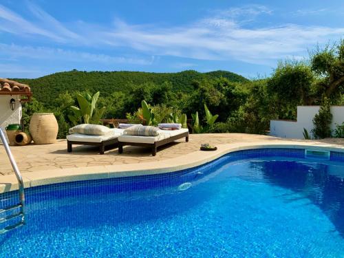 a swimming pool with two couches and a patioitures next to it at Villa Marlena, Calonge, Costa Brava,1 luxe private studio-appartement with private pool in quiet area, adults only, Catalonia, Spain in Calonge