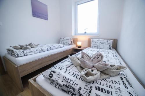 two twin beds in a room with a window at apartmány MAJKA in Holíč
