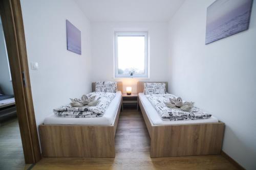 two beds in a room with a window at apartmány MAJKA in Holíč