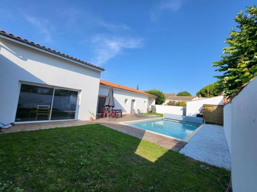 une cour arrière avec une piscine et une maison dans l'établissement Villa Beau Soleil, à Aytré