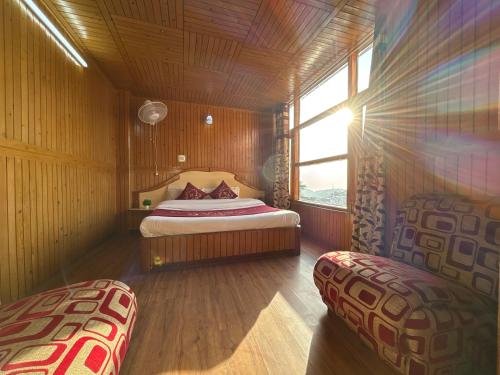 a bedroom with a bed in a room with a window at Hotel Amar Palace With mountain view in Shimla
