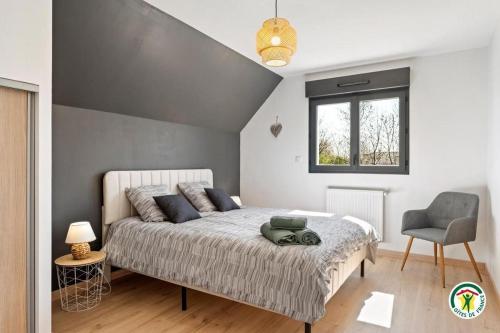 Un dormitorio con una cama grande y una silla. en La Villa Margaux, en Crasville-la-Mallet