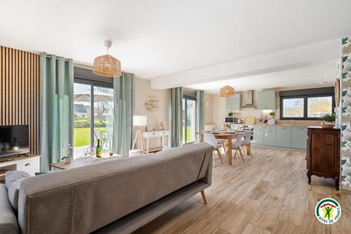 un salon avec un canapé et une cuisine dans l'établissement La Villa Margaux, à Crasville-la-Mallet