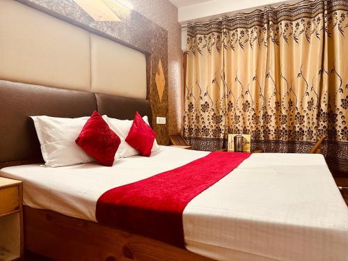 a bedroom with a large bed with red pillows at Village House Manali in Manāli