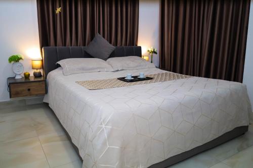a large white bed in a bedroom with curtains at Tritea Apartments in Golem