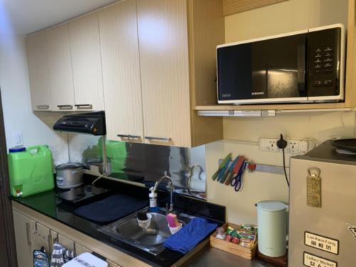 una cocina con fregadero y microondas en Sandstone Unit Brenthill Condo, en Baguio
